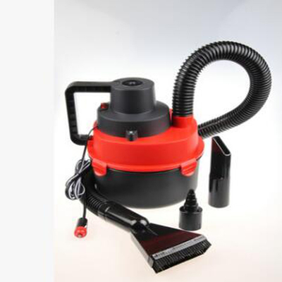 Aspirapolvere bagnato o asciutto dell'automobile con l'aspirapolvere automatico rosso tenuto in mano dell'aspirapolvere dell'accendino